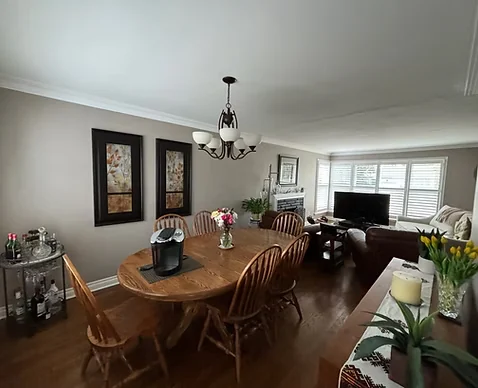 Finished dining room with light walls, white crown moulding and wood table
