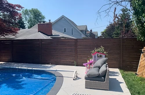 After: dark brown privacy fence beside the same swimming pool