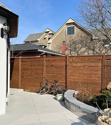 Warm brown fence panels beside a paved garden path