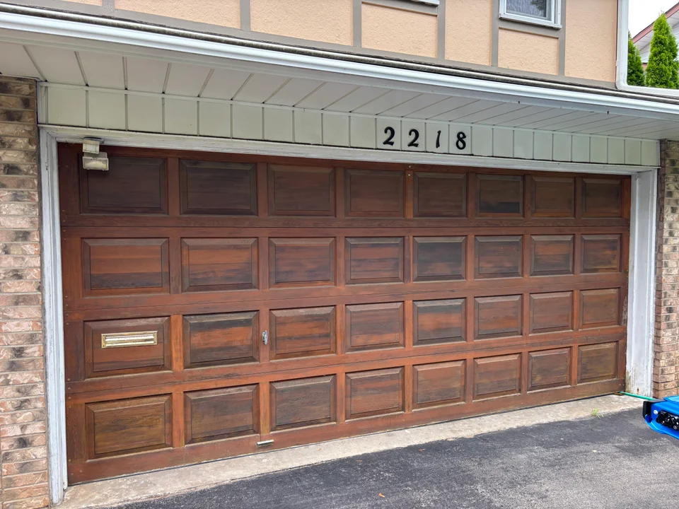 Classic brown panelled garage door beneath white exterior trim