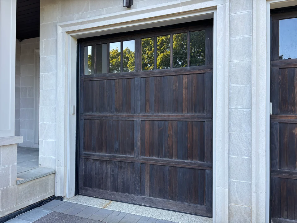 Close view of dark garage door panels framed by white trim