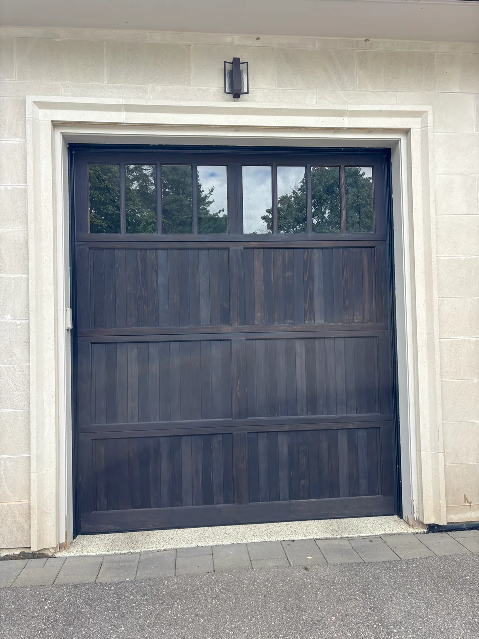 Full dark wood garage door with contrasting light surround