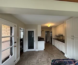 Finished kitchen with pale walls, white cabinets and white door trim
