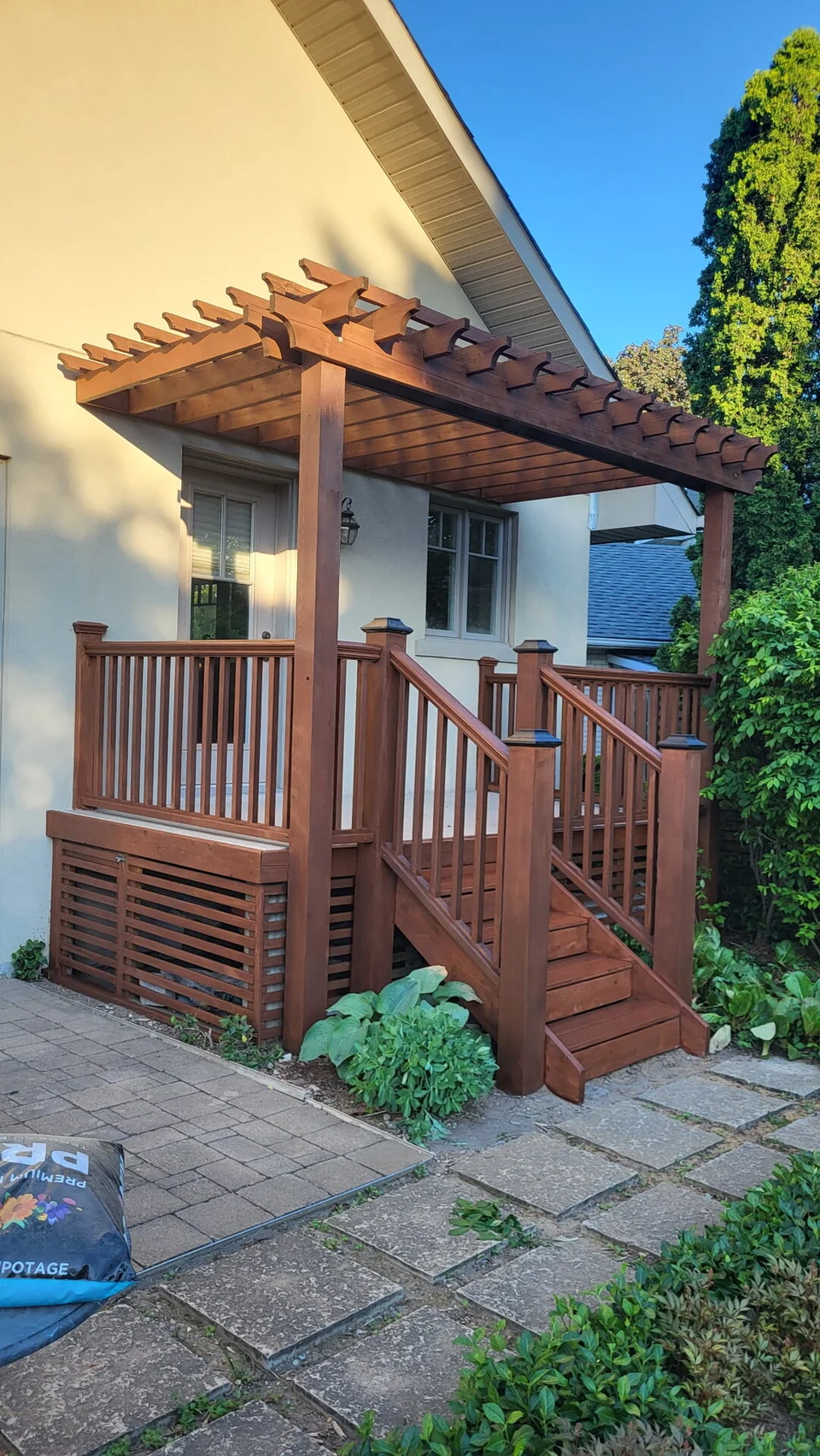 After: brown stained pergola, deck railings and entrance steps