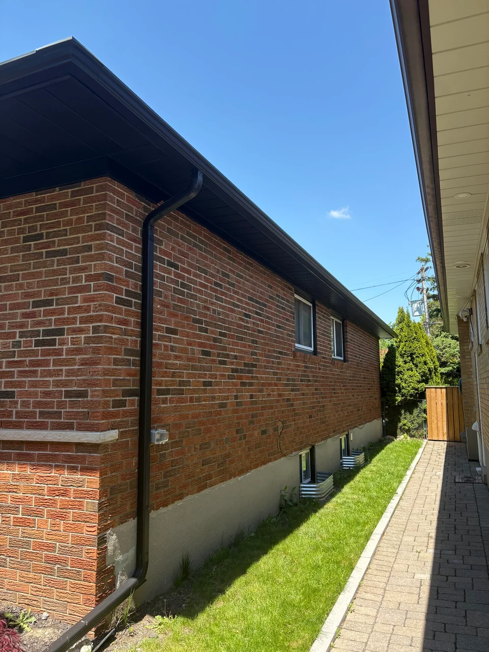 After: black soffit and fascia along the bungalow side wall